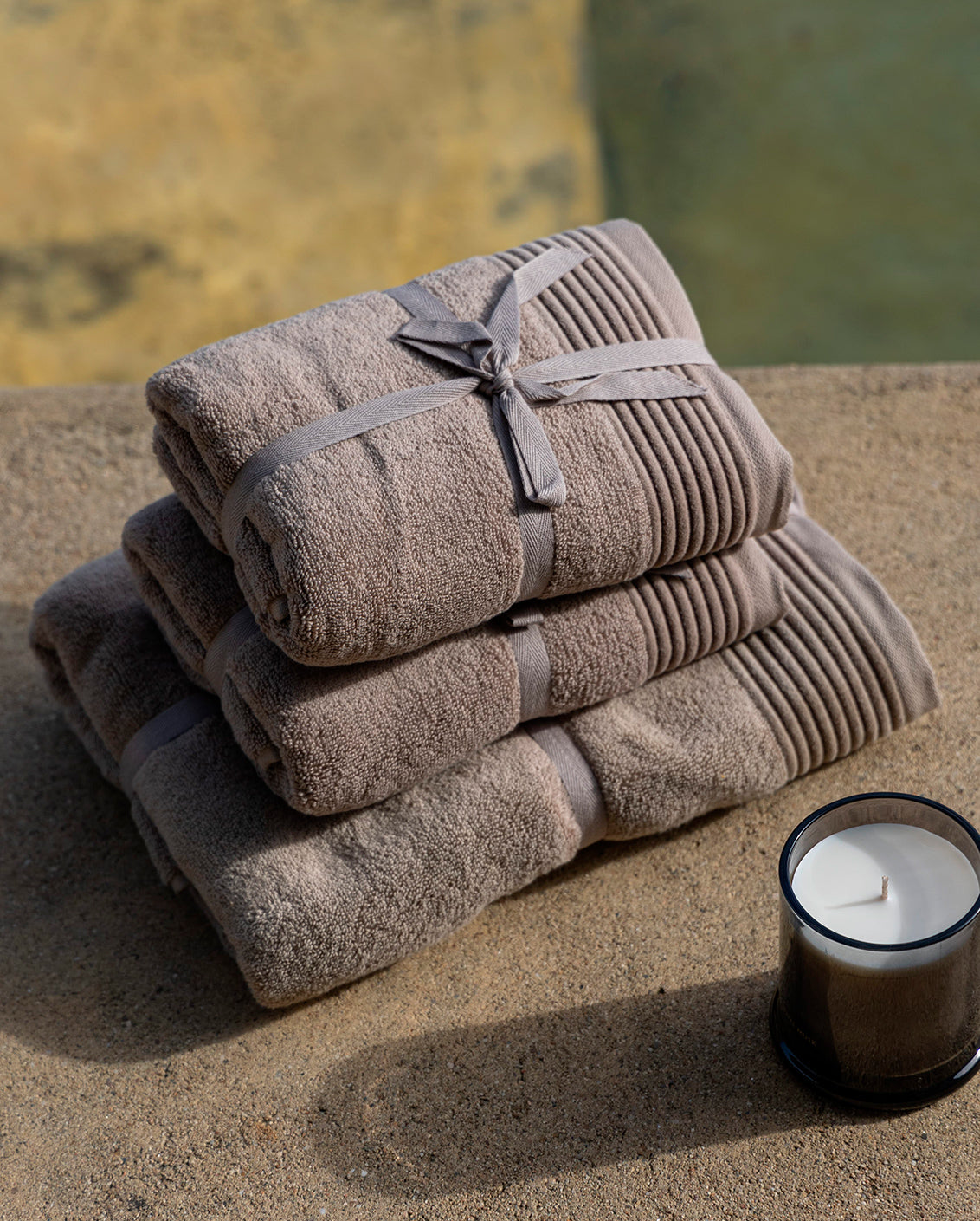 Photo of Coffee Cream Fluffy Bath Towel - A luxurious bath towel in a rich coffee cream color, displayed in a bathroom setting. The towel is folded neatly and placed on a countertop, creating a serene and elegant ambiance. The soft texture of the towel is visible, inviting the viewer to experience its plush comfort. 
