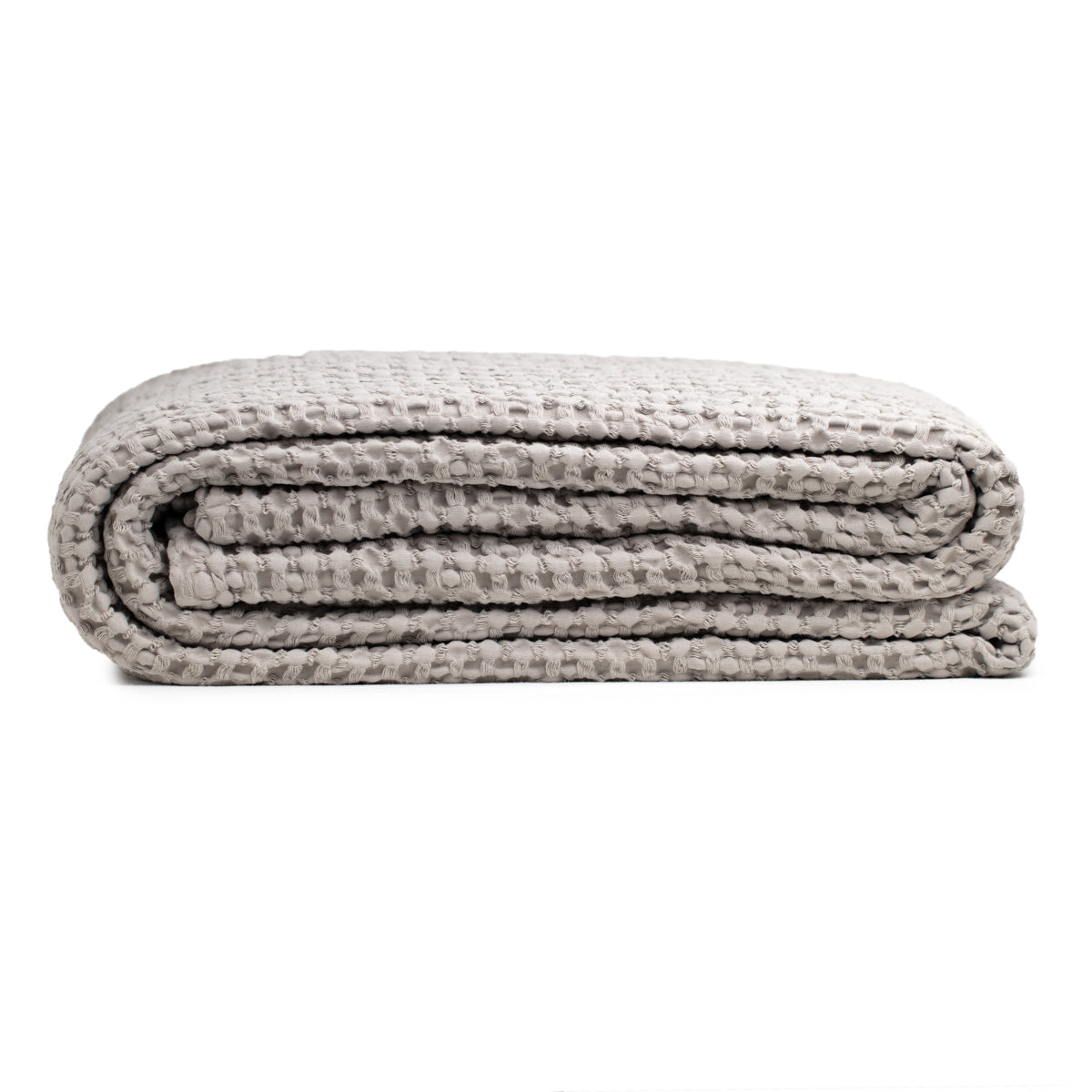 Bloom organic cotton throw in grey with honeycomb pattern, crafted from 100% cotton. Elegant and soft, this versatile bedspread adds a touch of serene style to any space, perfect for cozying up or enhancing home decor.