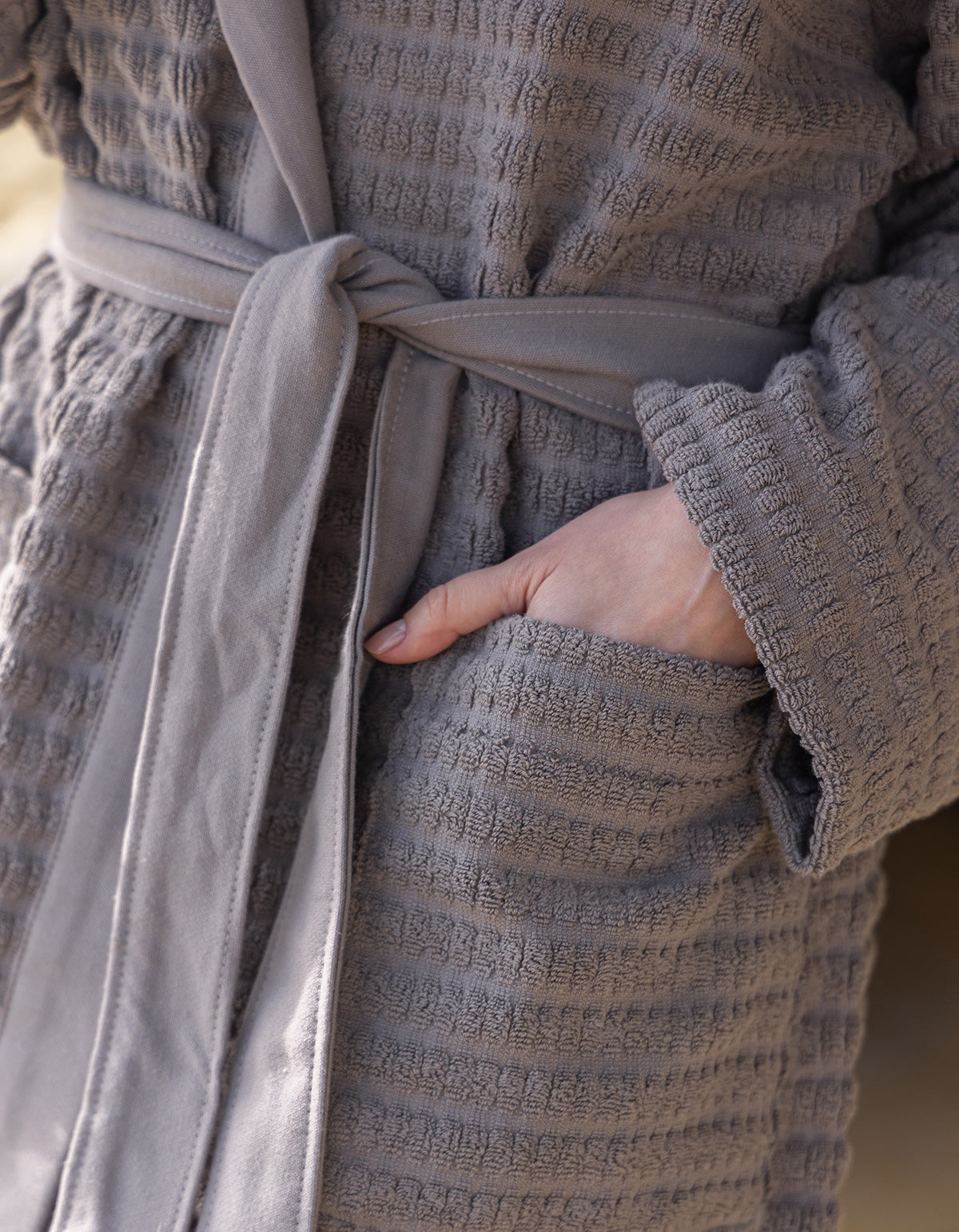 Grey Swell organic cotton bathrobe hanging neatly, highlighting its soft texture and elegant design