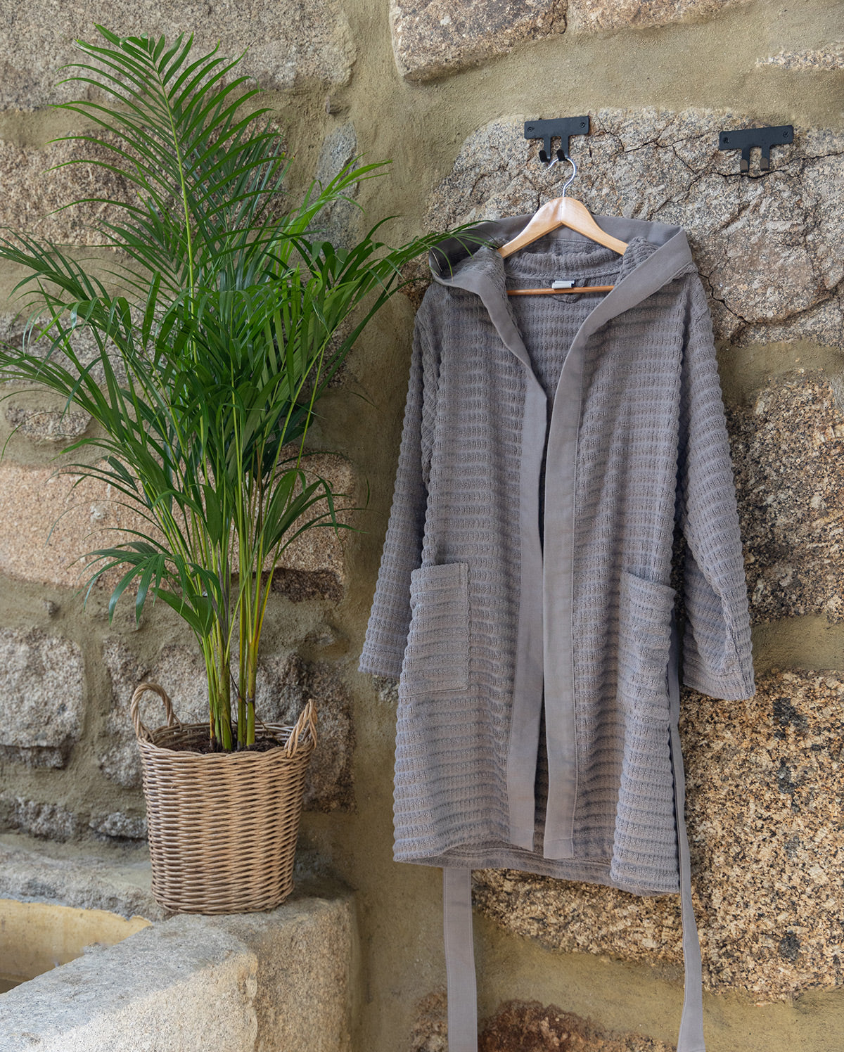 Grey Swell organic cotton bathrobe hanging neatly, highlighting its soft texture and elegant design