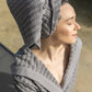 Grey Swell organic cotton bathrobe hanging neatly, highlighting its soft texture and elegant design