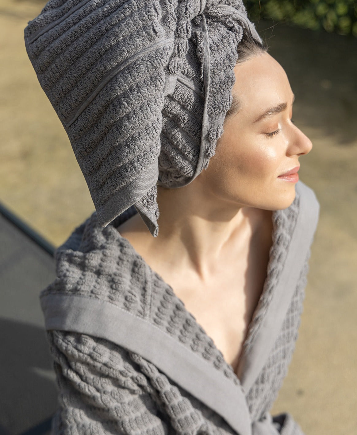 Grey Swell organic cotton bathrobe hanging neatly, highlighting its soft texture and elegant design
