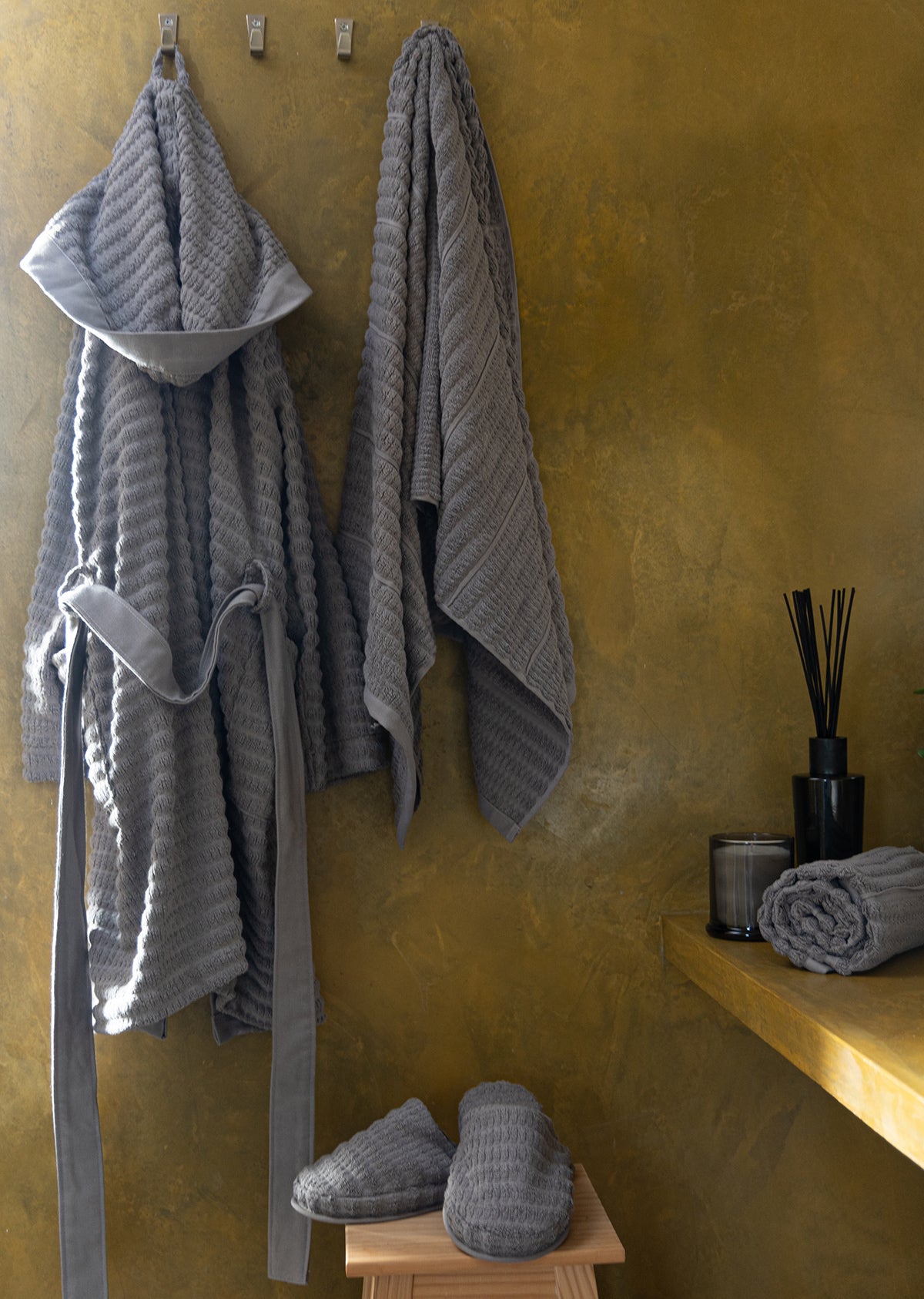 Grey Swell organic cotton bathrobe hanging neatly, highlighting its soft texture and elegant design