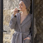 Grey Swell organic cotton bathrobe hanging neatly, highlighting its soft texture and elegant design